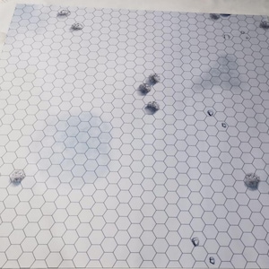 Könnte beinhalten: Ein großes, quadratisches Spielbrett mit einem weißen und grauen sechseckigen Gittermuster. Auf dem Brett sind mehrere kleine, graue, felsartige Formationen verstreut. Der Hintergrund hat ein bewölktes, blaues Himmelsdesign.