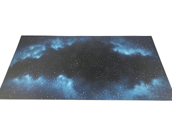 May include: A dark blue and black space-themed gaming mat with white stars and blue nebulae.