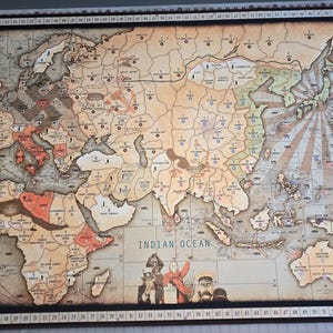 May include: A vintage-style world map, featuring continents and oceans labeled in English. The map has a weathered appearance with a brown and beige color scheme. The Pacific and Atlantic Oceans are clearly marked. The map is framed in black.