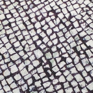 May include: A close-up of a white and black patterned fabric with a repeating pattern of small squares. The fabric has a textured surface.