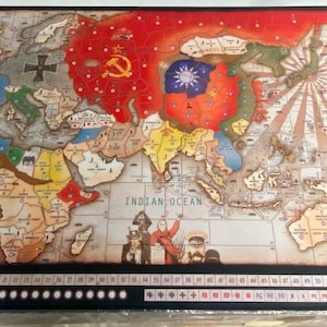 Puede incluir: Un mapa de juego de mesa de estilo vintage que presenta un mapa del mundo con varios territorios de colores. El mapa está impreso sobre un fondo marrón con un borde negro. El tablero de juego incluye una pista negra con números blancos y una pista roja con números blancos. El tablero de juego está etiquetado como "RISK".