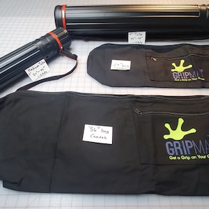May include: Three black canvas bags with red straps and a green logo that says "Gripmat Get a Grip on Your Game". Two black tubes with red caps and labels that say "Medium Tube 21" x 36" 3200" and "36" Tube 36" x 48" 3200".