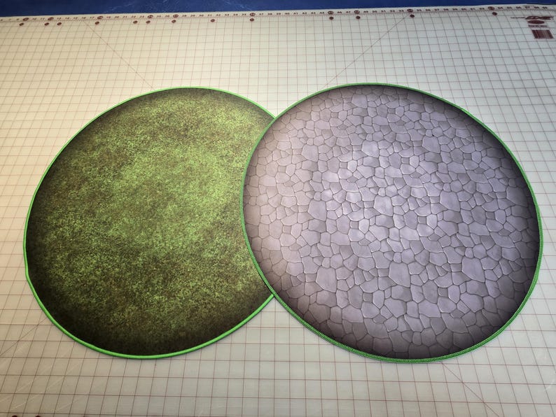 Peut inclure: Deux tapis de jeu ronds, l'un avec une texture de gazon vert et l'autre avec une texture de pierre grise.