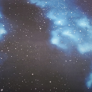 May include: A dark blue fabric with a galaxy print featuring white stars and blue nebulae.