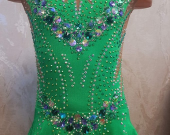 May include: A green leotard with a sparkly design. The leotard has a scoop neck and sleeveless design. The leotard is decorated with rhinestones and crystals.