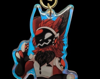May include: A red and black furry character with a white and red outfit is featured on a clear iridescent keychain with a gold star charm.