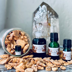 Puede incluir: Una variedad de productos de resina de benjuí. La imagen presenta un tarro de cristal transparente lleno de trozos de resina, junto con varias botellas de vidrio de diferentes tamaños que contienen líquido oscuro. Las botellas tienen tapas y etiquetas negras.