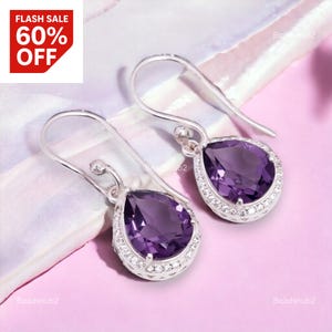Può includere: Orecchini pendenti in argento con pietre preziose viola a forma di pera. Ogni orecchino è circondato da un alone di piccole pietre trasparenti. L'immagine include un grafico rosso e bianco "FLASH SALE 60% OFF".