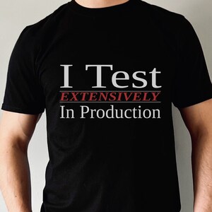 May include: A black t-shirt with the text "I Test Extensively In Production" in white and red.