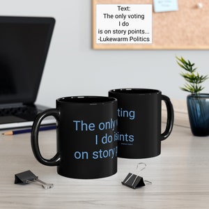 Peut inclure: Deux tasses à café noires avec du texte blanc qui dit "The only voting I do is on story points... -Lukewarm Politics". Le texte est en bleu clair.
