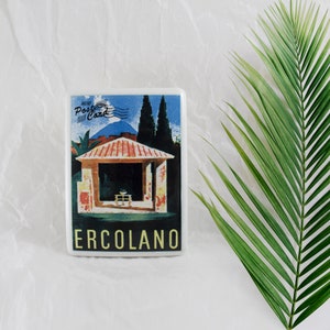 May include: A white ceramic mini postcard with a colourful illustration of a building with a red roof and a blue sky. The text "MINI POST CARD" is in the top left corner and "ERCOLANO" is in the bottom centre.