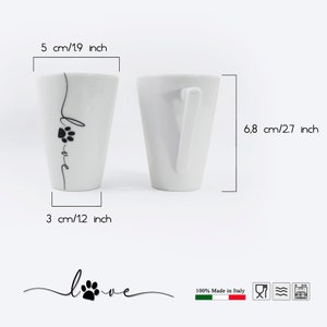 Puede incluir: Taza de caf&eacute; de cer&aacute;mica blanca con una huella de pata negra y la palabra "love" escrita en el lateral. La taza mide 6,8 cm de alto y 3 cm de ancho. Est&aacute; hecha en Italia.