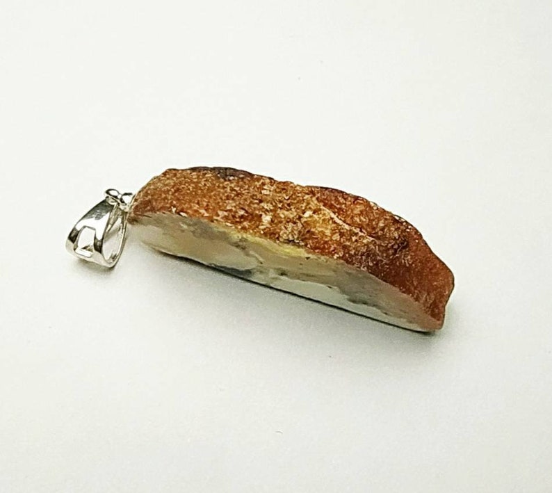 Pendant made of natural amber A piece of bread with a crust.
