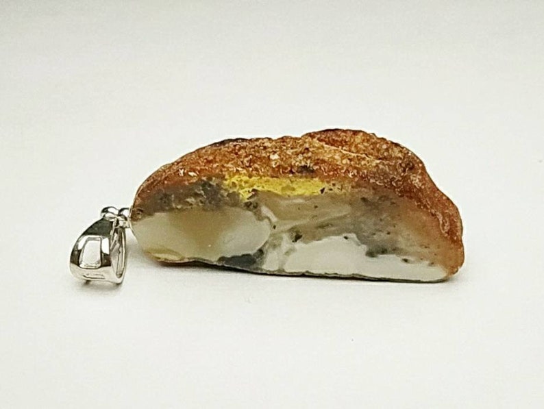 Pendant made of natural amber A piece of bread with a crust.