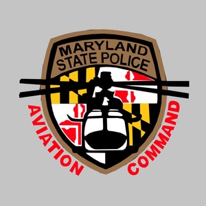 May include: A brown shield with the words "Maryland State Police" and "Aviation Command" around the perimeter. The shield features the Maryland state flag and a black helicopter.