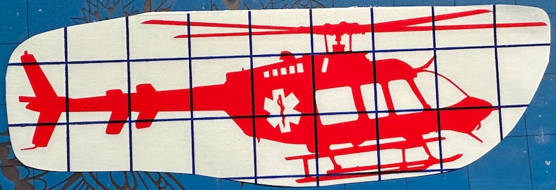 Może przedstawiać: Czerwona sylwetka helikoptera z białym symbolem gwiazdy życia po bokach. Helikopter znajduje się na białym tle.