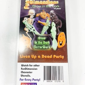 May include: A package of 12 glow-in-the-dark Halloween party decorations. The package features a witch, a skeleton, a ghost, and a jack-o-lantern. The text on the package reads "Dimensions Glow in the Dark TerrorWare Liven Up a Dead Party".
