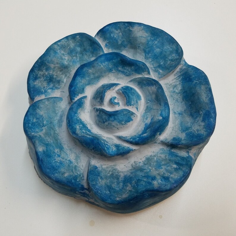 Pu&ograve; includere: Una scultura di rosa in ceramica blu e bianca. La rosa &egrave; dipinta in tonalit&agrave; di blu con un centro bianco.
