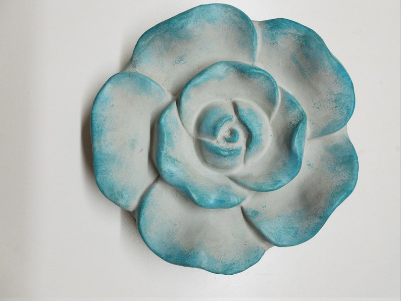 Pu&ograve; includere: Una grande rosa in ceramica bianca con una glassa blu-verde. La rosa &egrave; scolpita con petali dettagliati ed &egrave; un decoro da parete.