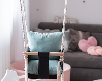 A swing for children with OhSwing Baby Black backrest.
