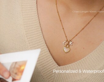 May include: Gold necklace with a heart-shaped pendant and two initial charms. The chain is 40mm or 45mm long. The text "Personalized & Waterproof" is visible at the bottom of the image.