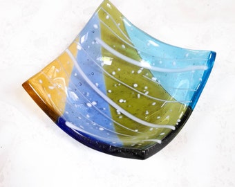 Fused glass ring dish in spring colours of yellow, blue and green with a white pattern. A contemporary square shaped glass trinket dish.