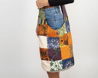 May include: A patchwork shoulder bag with a variety of colorful fabric squares. The bag features a button closure and a long strap with a striped pattern. The bag is carried over the shoulder.