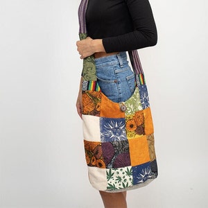 May include: A patchwork shoulder bag with a variety of colorful fabric squares. The bag features a button closure and a long strap with a striped pattern. The bag is carried over the shoulder.