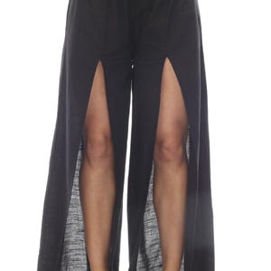 May include: Black wide-leg pants with a high waist and two slits up the sides of the legs.