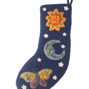 Op de afbeelding: Een donkerblauwe vilten kerstkous met geborduurde ontwerpen van een gele zon, een grijze maansikkel met een gezicht en een kleurrijke vlinder. De kous is versierd met kleine witte stervormige accenten en heeft een lus aan de bovenkant.