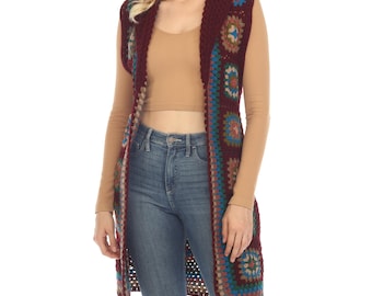 May include: A long, burgundy crochet vest with a hood. The vest features a geometric pattern with colourful squares and circles.
