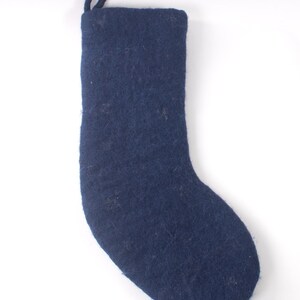 Op de afbeelding: Een donkerblauwe kerstkous van vilt met een gestructureerde, matte afwerking en een bijpassende stoffen lus aan de bovenhoek om op te hangen. De kous heeft een eenvoudig, effen ontwerp met een zachte, vezelige textuur aan het oppervlak.