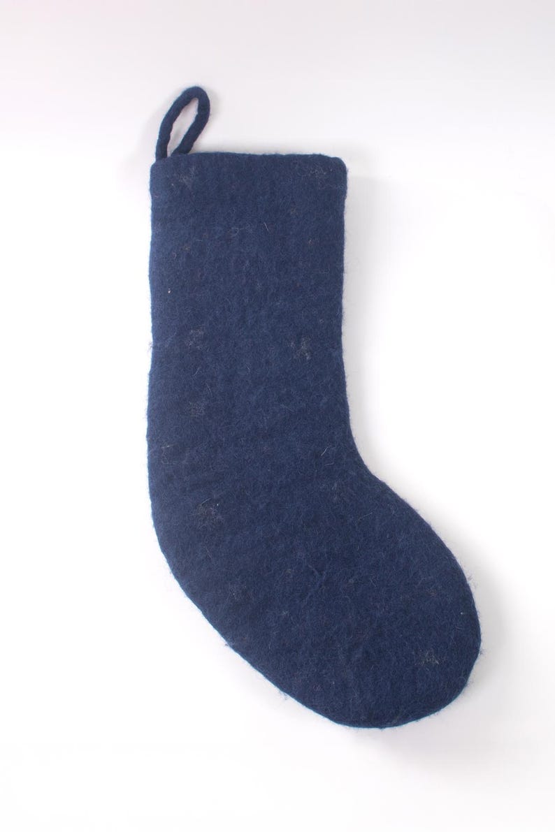 Op de afbeelding: Een donkerblauwe kerstkous van vilt met een gestructureerde, matte afwerking en een bijpassende stoffen lus aan de bovenhoek om op te hangen. De kous heeft een eenvoudig, effen ontwerp met een zachte, vezelige textuur aan het oppervlak.