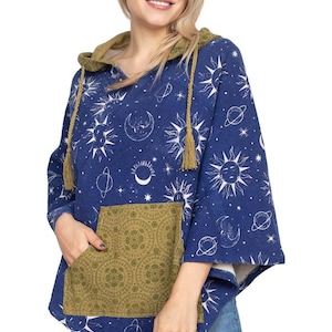 May include: A blue poncho-style hoodie with a celestial pattern of suns, moons, and planets. It features a patterned pocket and a green-lined hood with drawstring ties. The garment is worn with blue jeans.