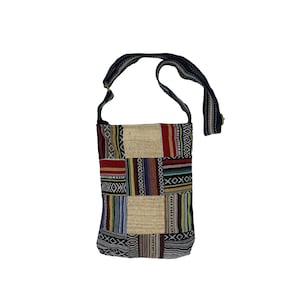May include: A patchwork style shoulder bag with a black strap. The bag is made of different colored fabrics with geometric patterns.