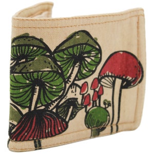 Pu&ograve; includere: Un portafoglio in tela beige con una stampa di funghi colorati. I funghi sono rossi, verdi e neri.