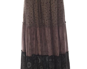 May include: A tiered maxi skirt featuring a brown top section with a black moon and star print, a mauve middle section with a celestial pattern, and a black bottom tier with a detailed white sun and moon graphic print, finished with an elastic waist.
