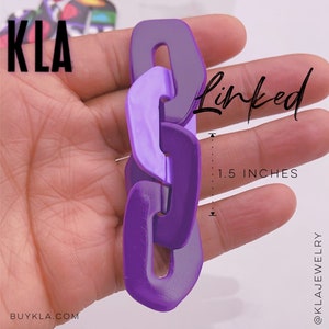 May include: Purple plastic chain link hair clip, measuring 1.5 inches in length.  The clip is made of two shades of purple, a lighter shade and a darker shade.  The text "Linked" is written in white on the image.