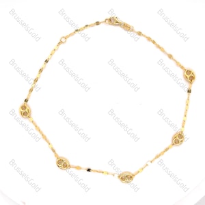 May include: A gold chain necklace with a delicate design featuring multiple small oval-shaped links. The chain has a lobster clasp closure.