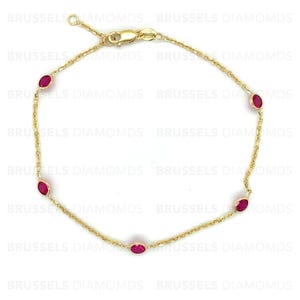 May include: A gold chain bracelet with five oval-shaped red gemstones. The bracelet has a lobster clasp closure.