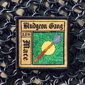 May include: A brown and black embroidered patch with the text "Bludgeon Gang" and a green and yellow illustration of a mace with the text "2.5 lb Mace".