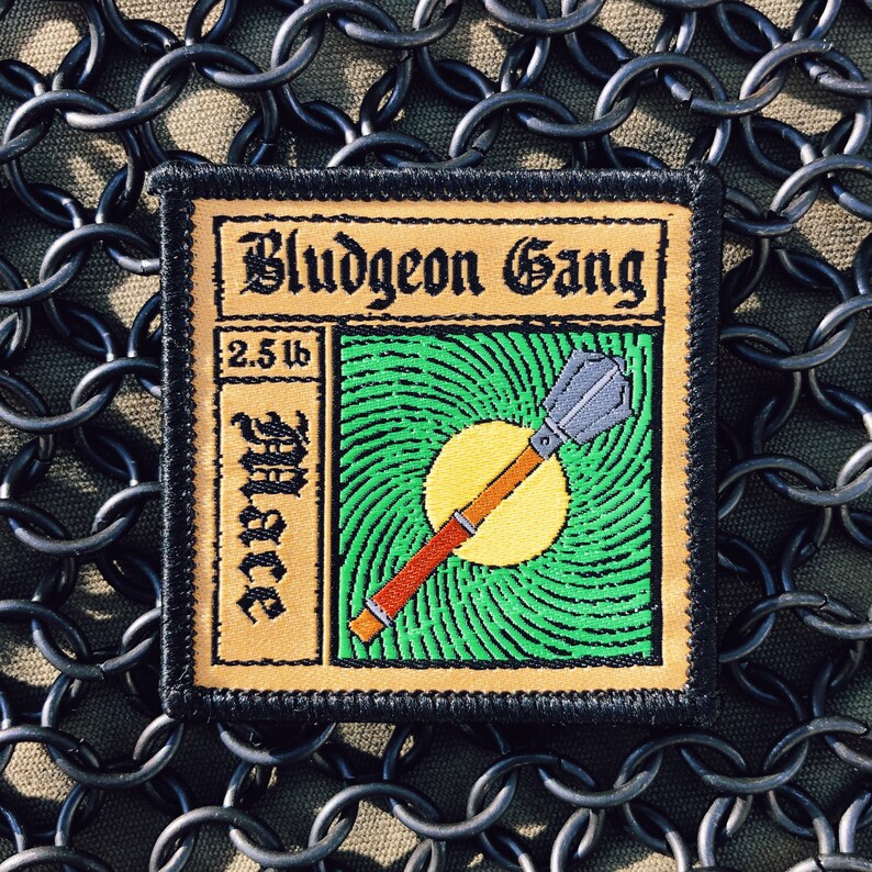 May include: A brown and black embroidered patch with the text "Bludgeon Gang" and a green and yellow illustration of a mace with the text "2.5 lb Mace".
