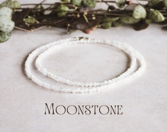 Puede incluir: Un delicado collar de piedra lunar blanca con cierre de plata. El collar está hecho de pequeñas cuentas redondas y está en capas para un look sutil y elegante.