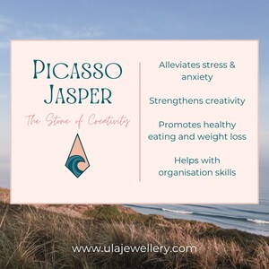 May include: A pink and white card with the text "Picasso Jasper" and "The Stone of Creativity". The card also features a blue and white wave design in a diamond shape. The card lists the benefits of Picasso Jasper, including alleviating stress and anxiety, strengthening creativity, promoting healthy eating and weight loss, and helping with organization skills. The card also includes the website address "www.ulajewellery.com".