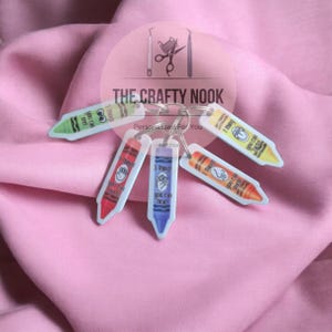 May include: A set of five colorful crayon-shaped keychains on a metal ring. Each keychain features a different color and text: 5 things you can see, 4 things you can touch, 3 things you can hear, 2 things you can smell, and 1 thing you can taste.