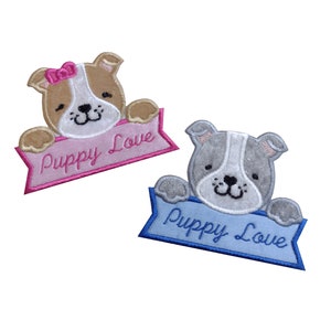 May include: Two embroidered iron-on patches featuring cartoon puppies holding banners that say "Puppy Love". One patch is pink and the other is blue.