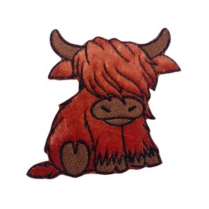 May include: An embroidered patch of a Highland cow with a fluffy red mane. The cow is sitting with its legs tucked under its body.