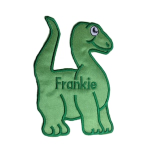 May include: Green felt dinosaur applique with the name Frankie embroidered on the body.