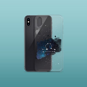 Peut inclure: Une coque de t&eacute;l&eacute;phone transparente avec un design aquarelle noir et bleu de la constellation de la Balance. La coque est con&ccedil;ue pour un smartphone avec un dos noir et un objectif d'appareil photo unique.