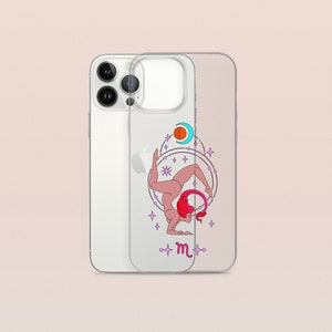 Puede incluir: Una funda transparente para tel&eacute;fono con un dise&ntilde;o de una mujer en una postura de yoga con una cola de escorpi&oacute;n y la letra "m" en el centro. El dise&ntilde;o est&aacute; rodeado de estrellas y planetas.
